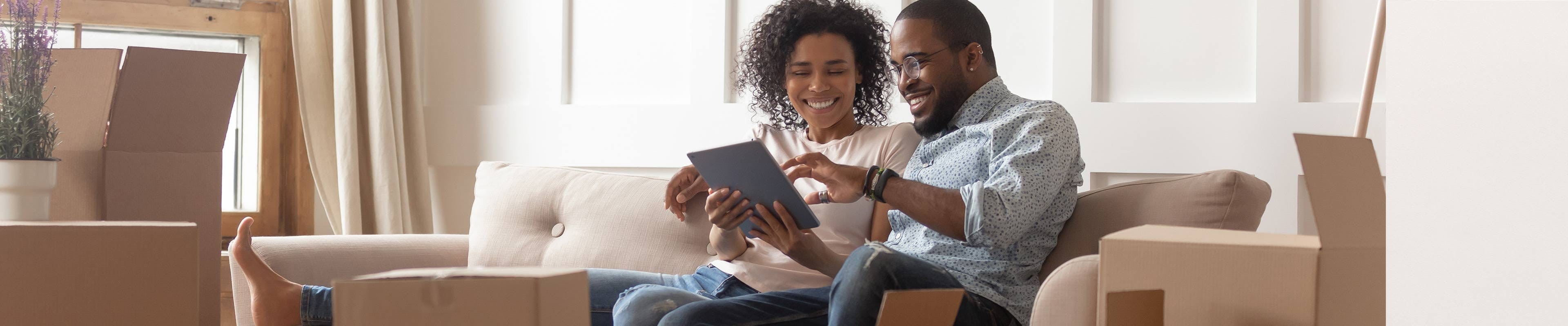 Image of a couple looking online after moving into a new home.