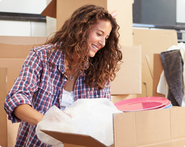 Young woman packing moving boxes