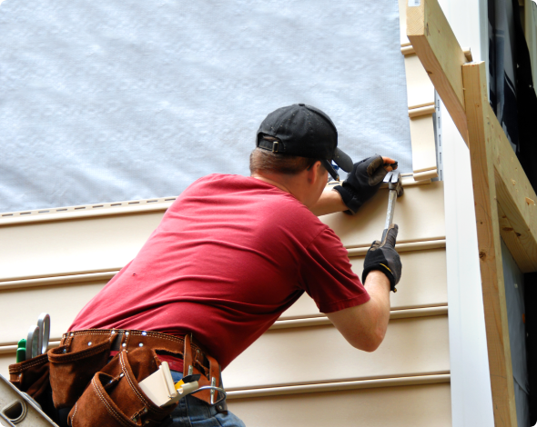 Homeowner installing a siding to his home