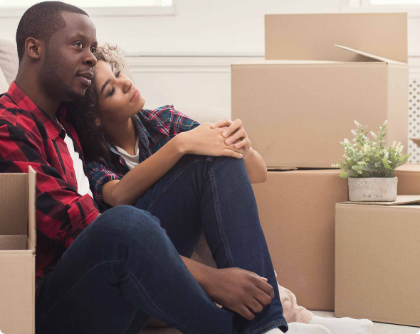 a man and woman hug while surrounded by boxes