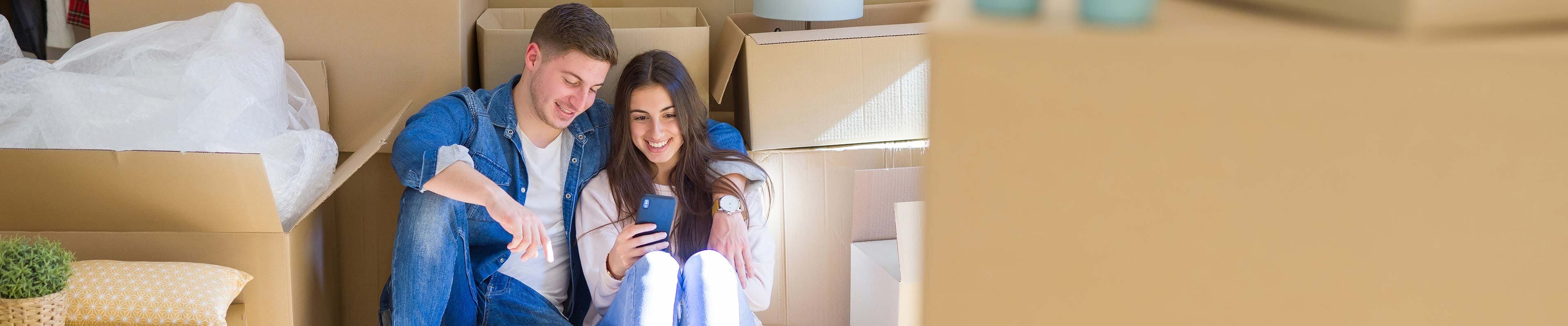 couple sitting among boxes after moving
