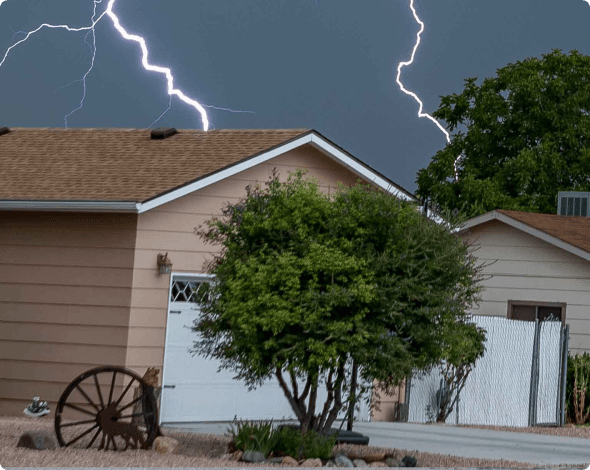 Image of homes in a neighborhood with lightning striking from above.