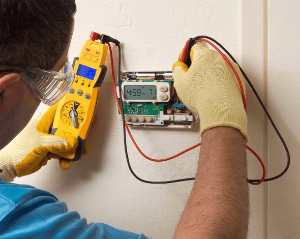 Photo of a furnace serviceman working on a thermostat.